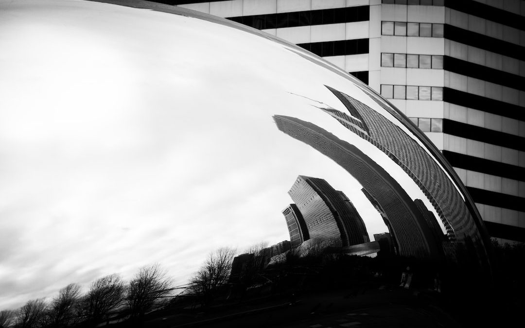 a large metal object in front of a tall building