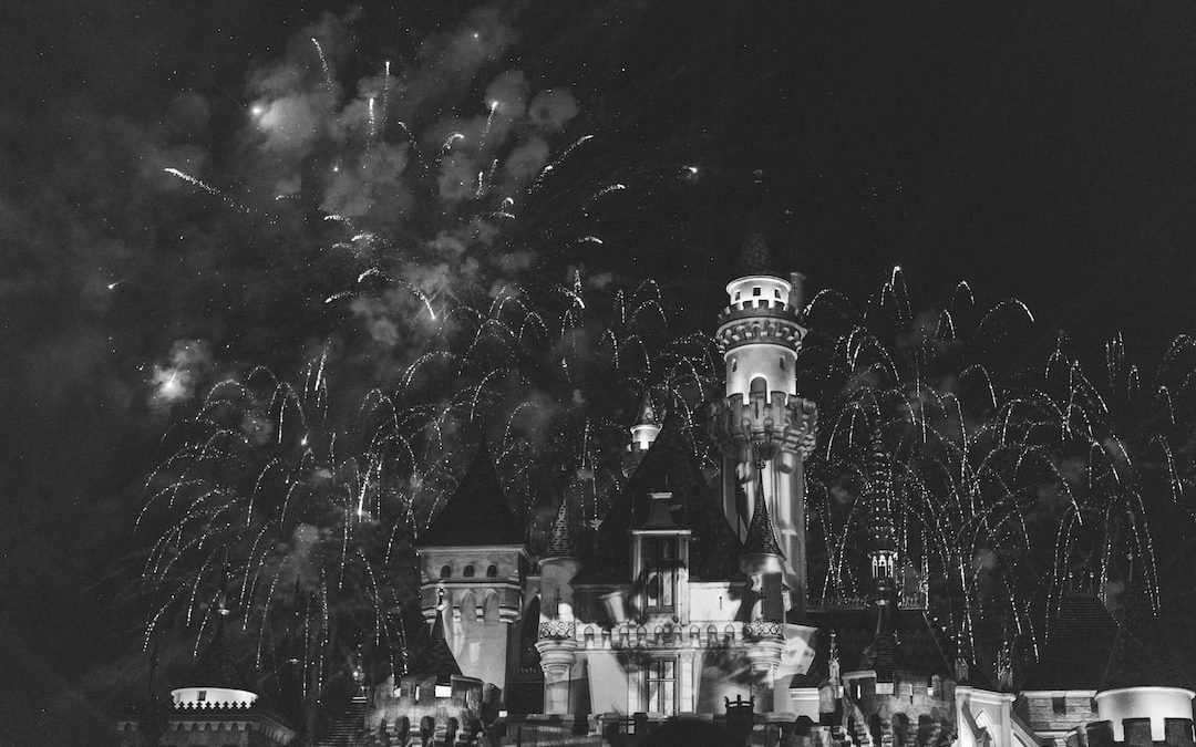 a black and white photo of a castle with fireworks