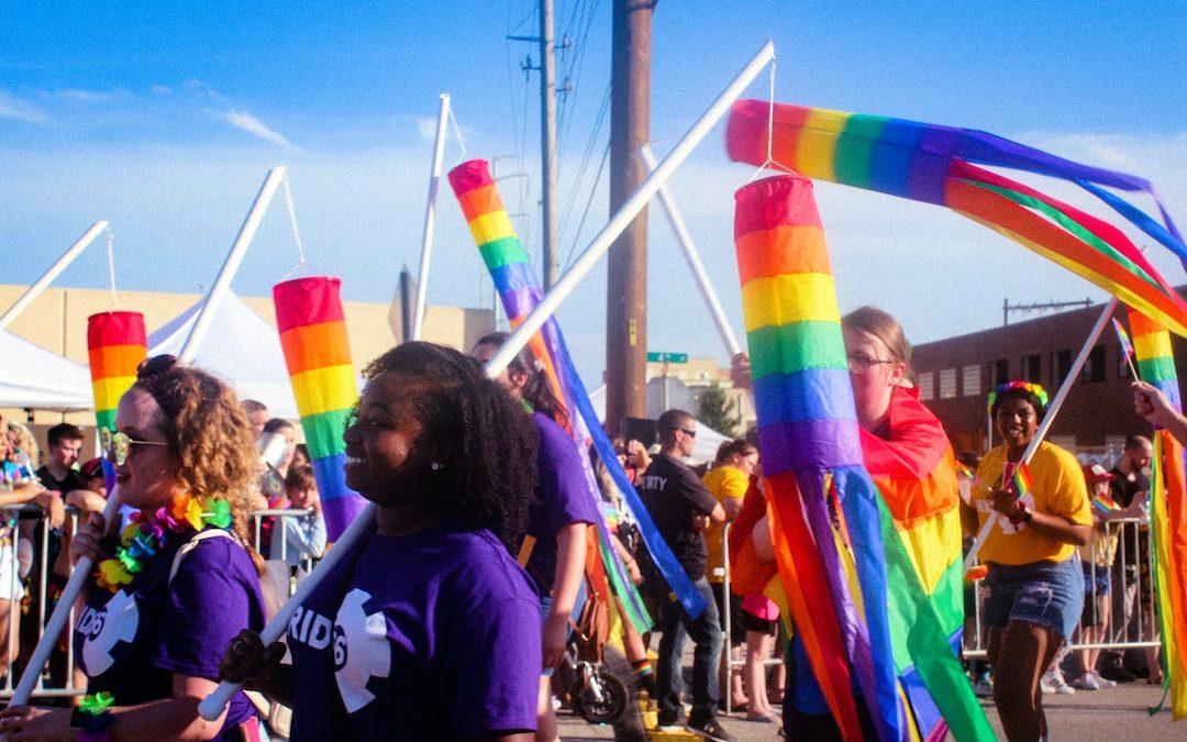 women carrying flag while walking on road
