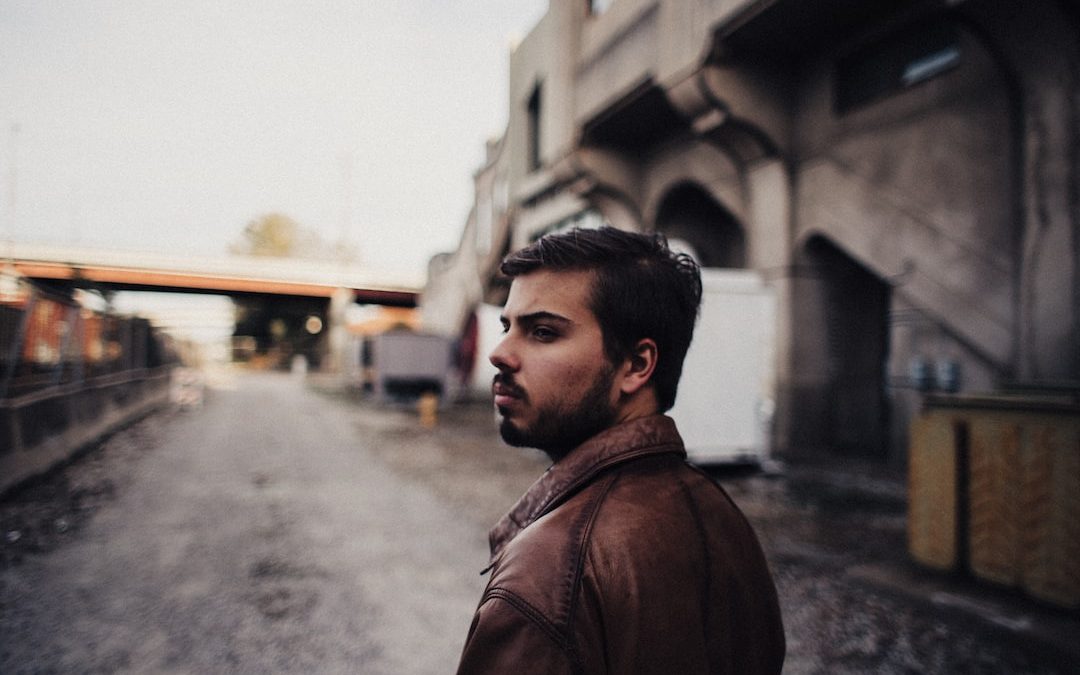 a man standing on a street next to a building