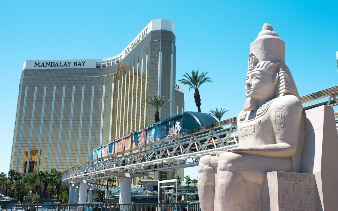 a statue of a person holding a torch in front of a bridge