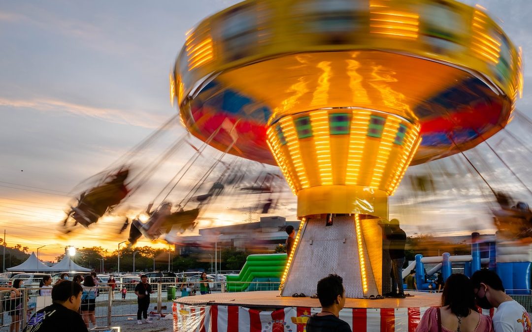 a carnival ride with people standing around it