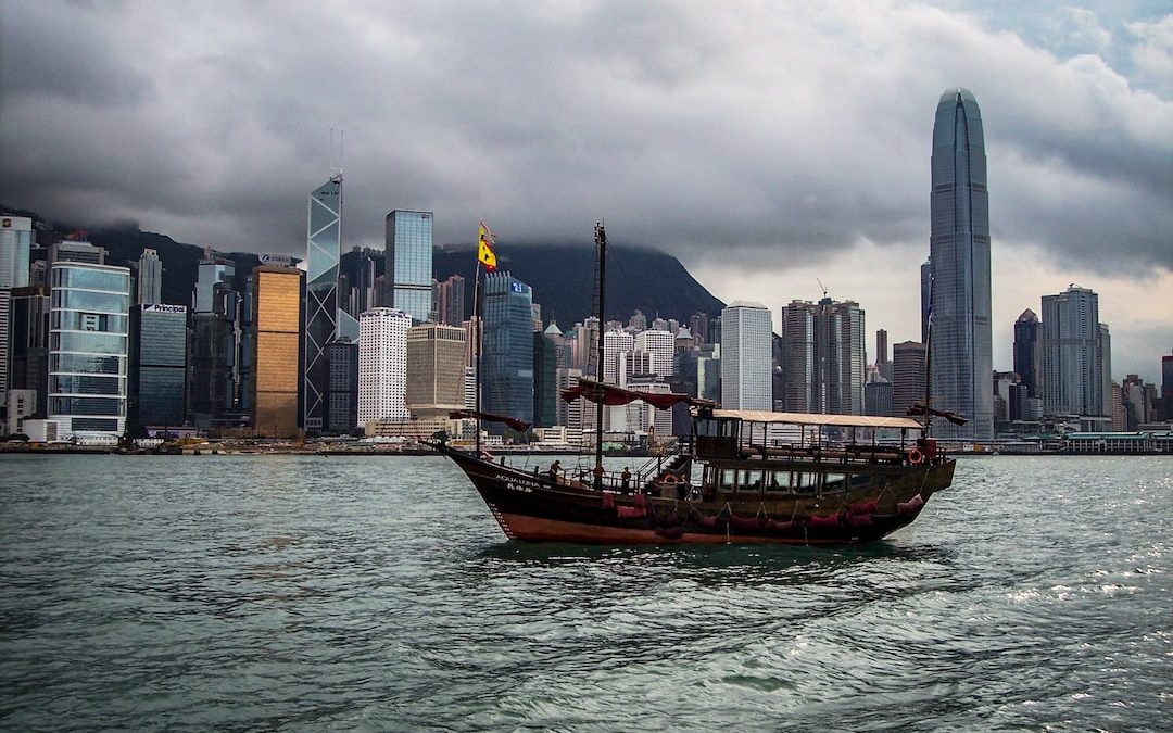 boat on water beside high-rise buildings