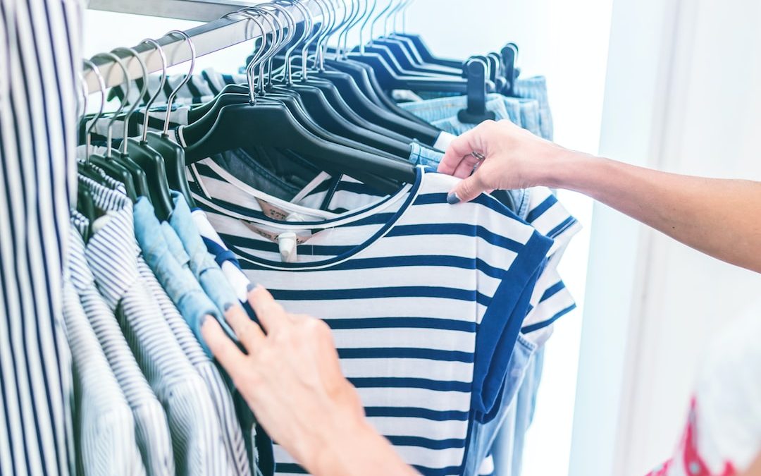 person holding white and black striped shirt