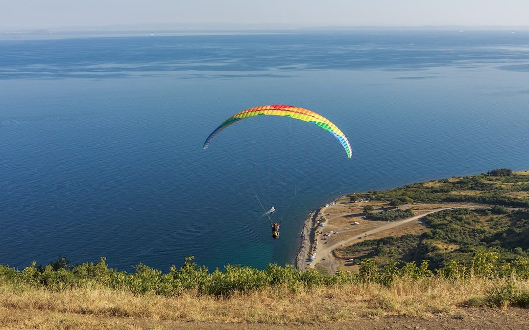 a paraglider is flying over a body of water