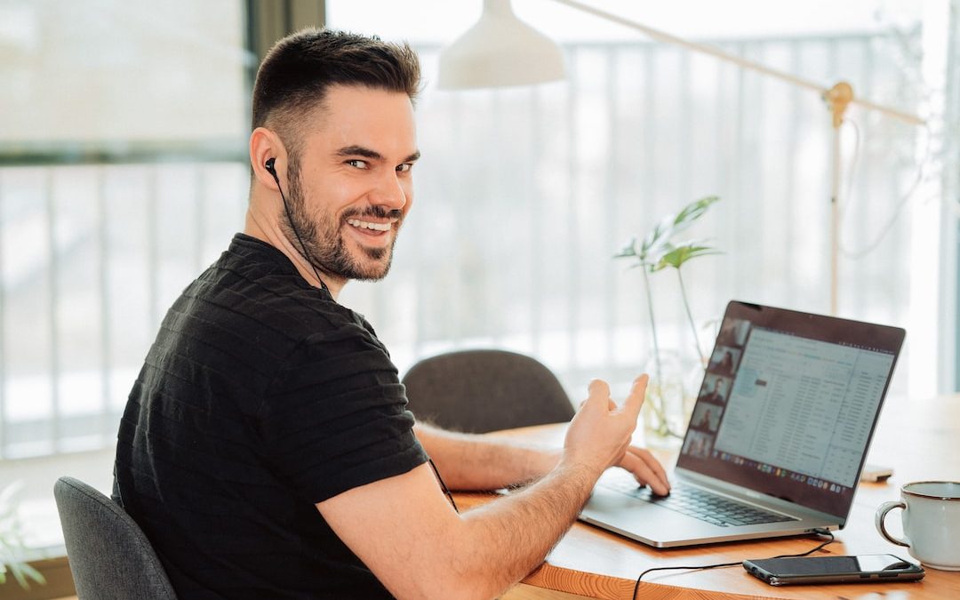 man in black t-shirt using macbook pro