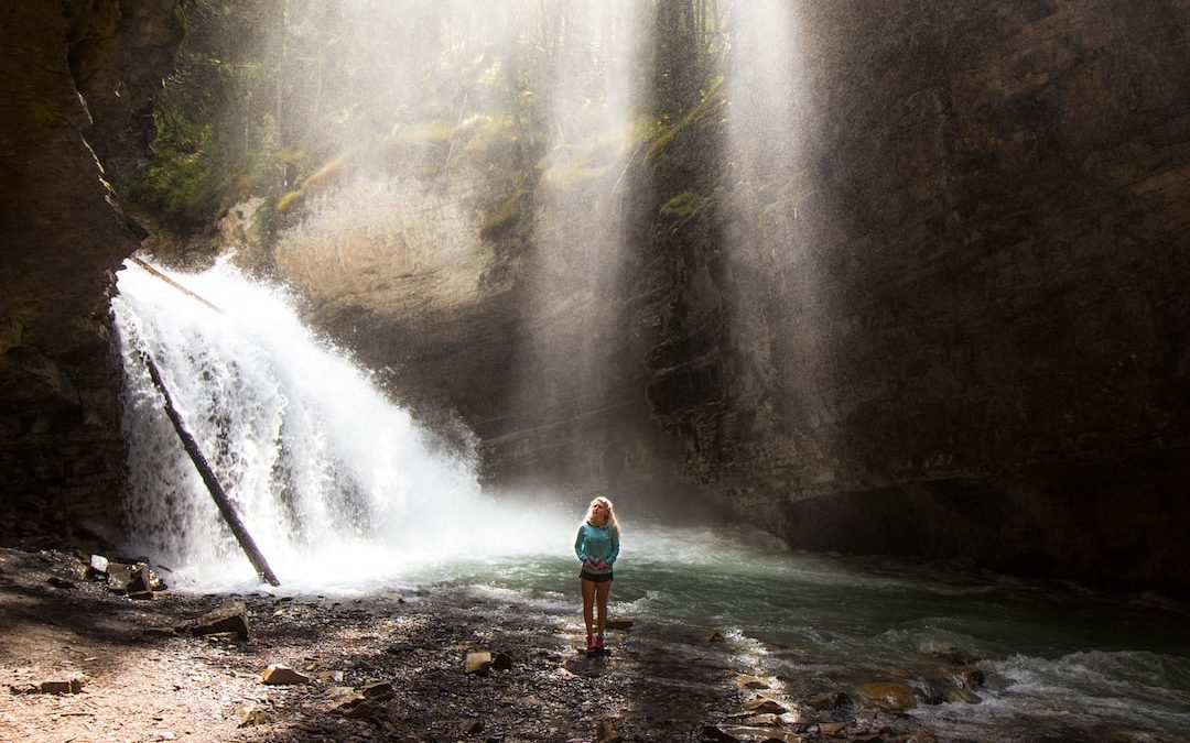 woman standing near river under gray sky during daytime