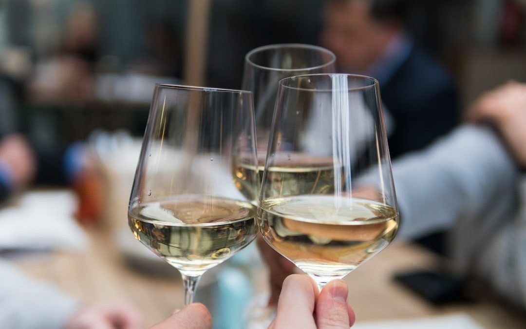 three people having a toast using three clear crystal wine glasses