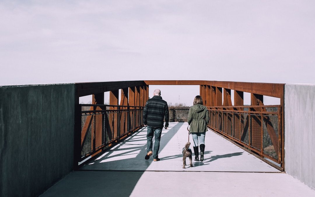 dog, man, and woman about to cross on bridge