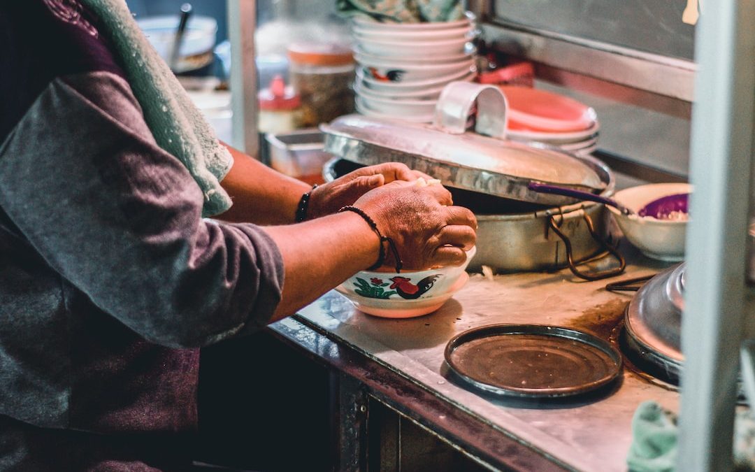 person in gray long sleeve shirt holding white ceramic bowl