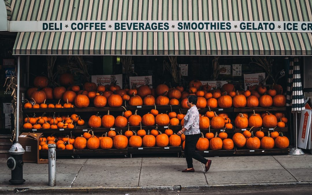 woman walking along pumpkin store