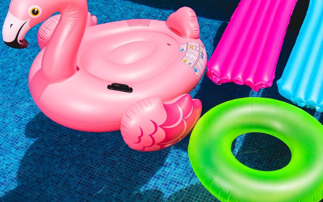 pink inflatable flamingo and green inflatable ring