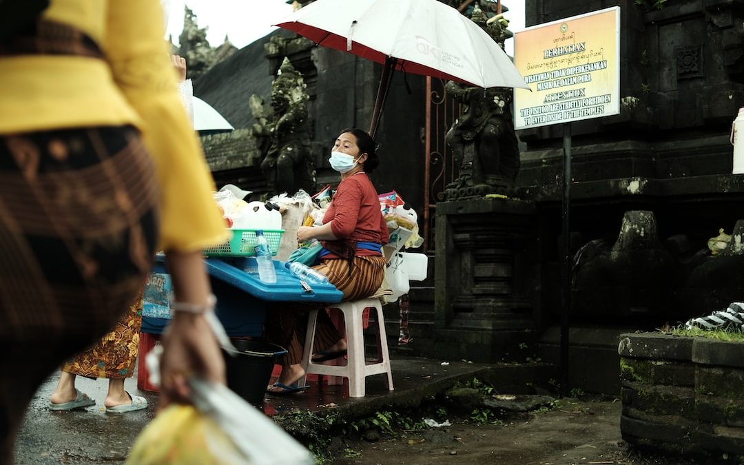 a woman wearing a face mask sitting at a table