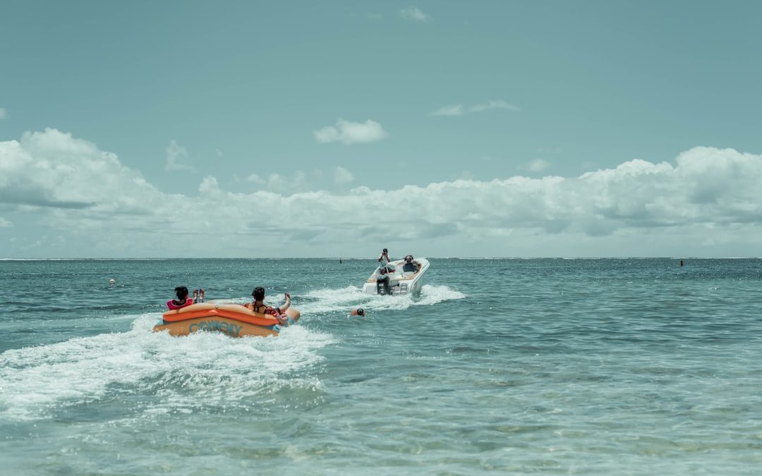 orange and white inflatable boat on sea during daytime