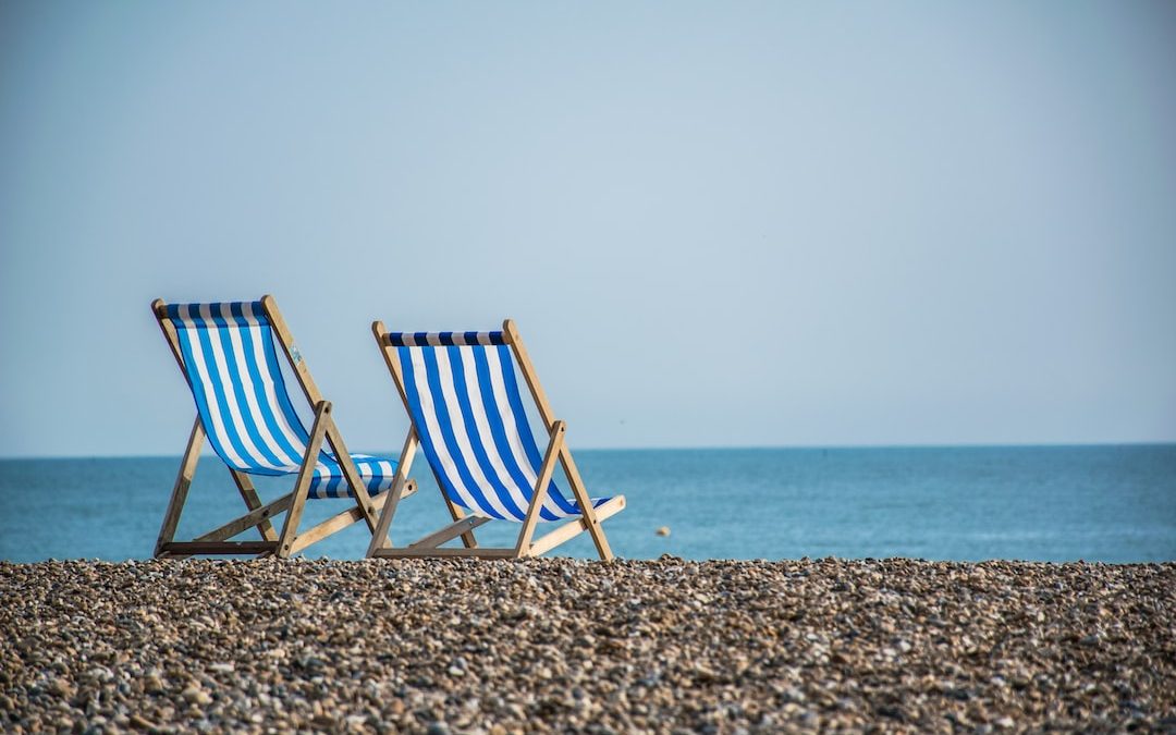 blue and white striped folding chair on beach during daytime