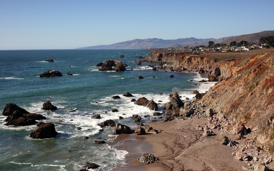 a view of a rocky beach with waves crashing on the shore