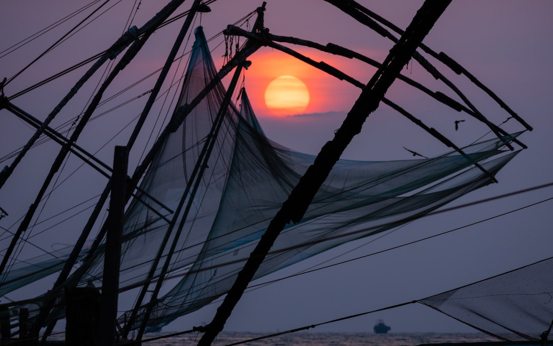 black sailing boat under sunset