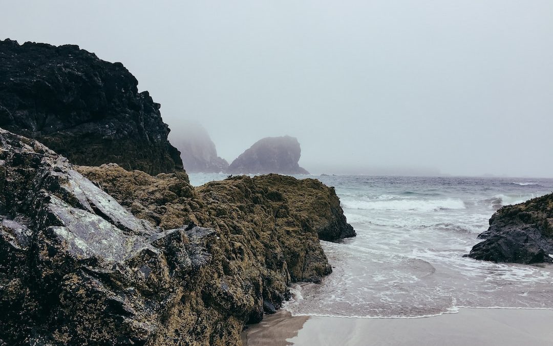 time lapse photography of seashore near boulder