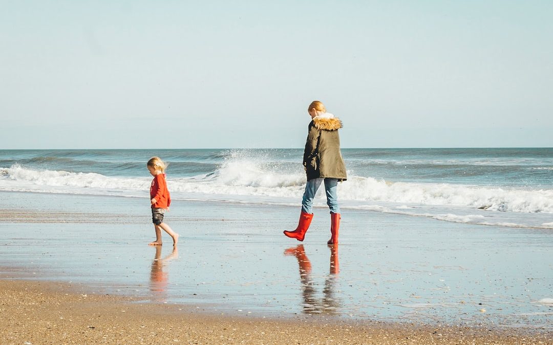 woman and child standing on seashore