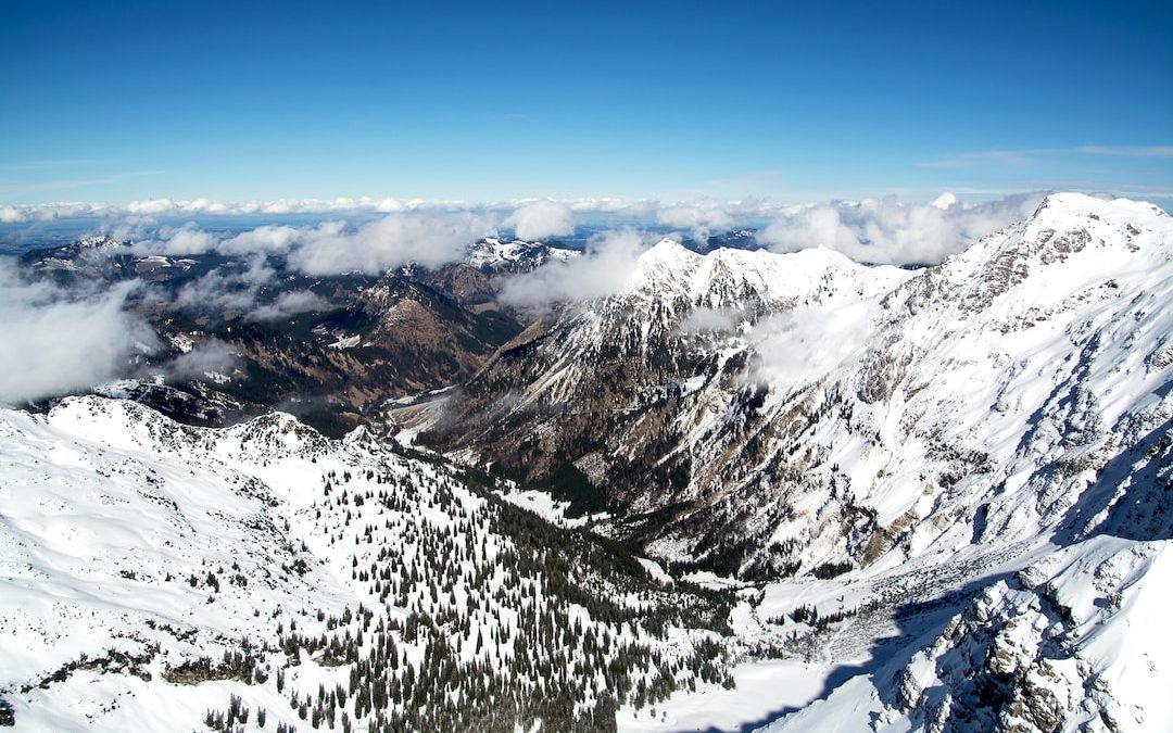 aerial photo of mountains covered with snow under cloudy sky