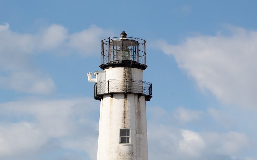 white and black lighthouse under blue sky during daytime
