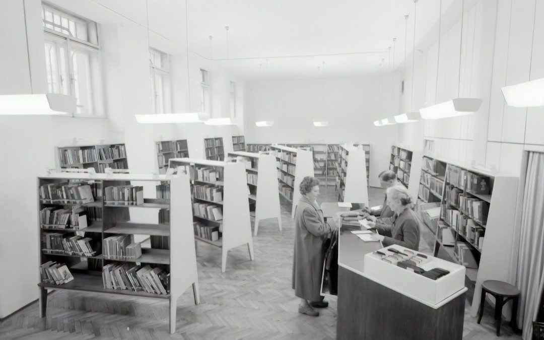 grayscale photography of people inside book store
