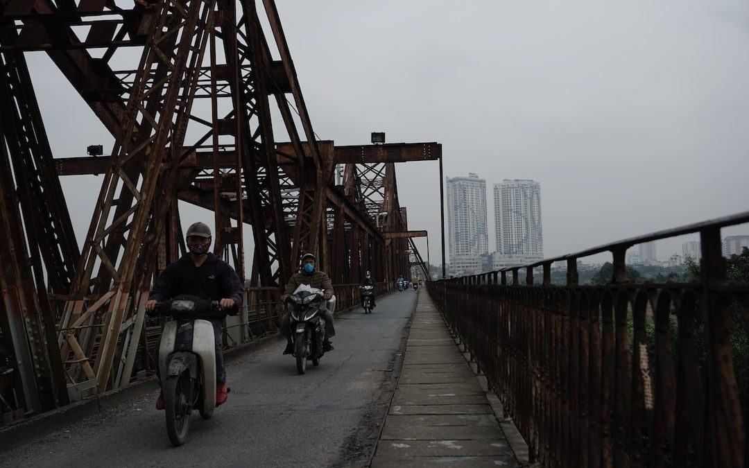 a couple of people on motor bikes on a bridge