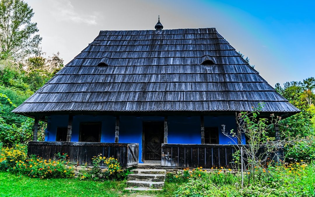 a small blue house with a black roof