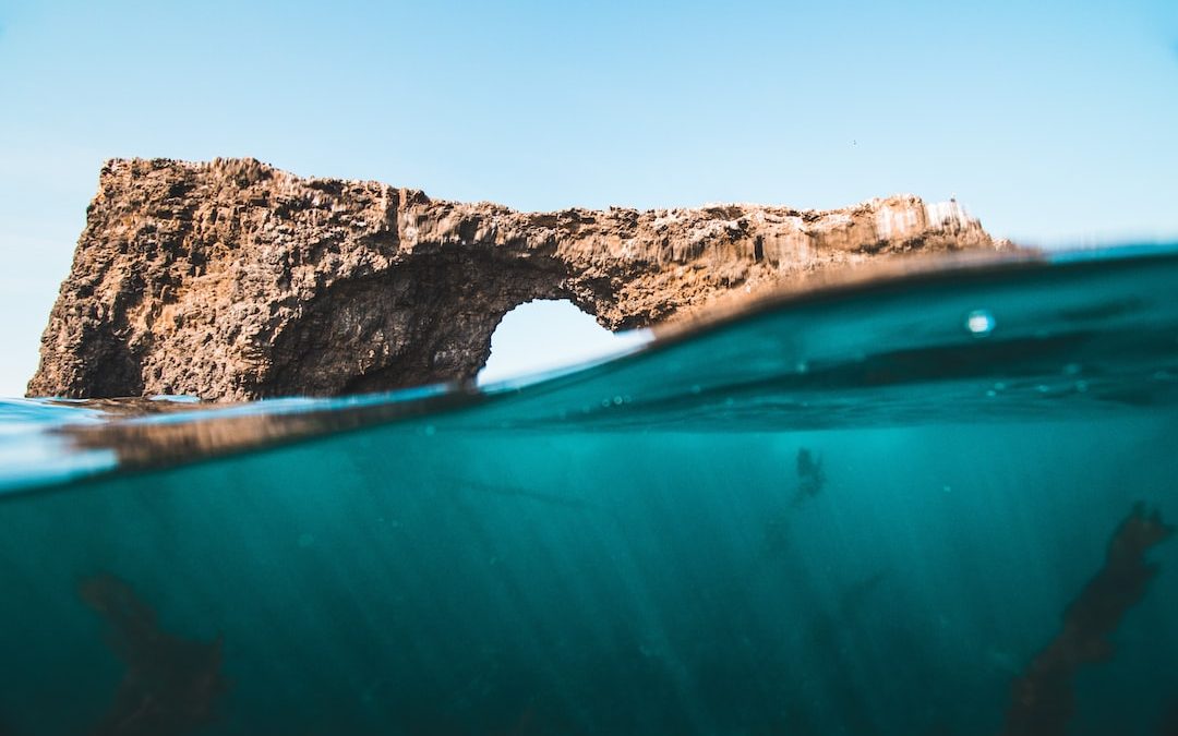 brown rock over body of water