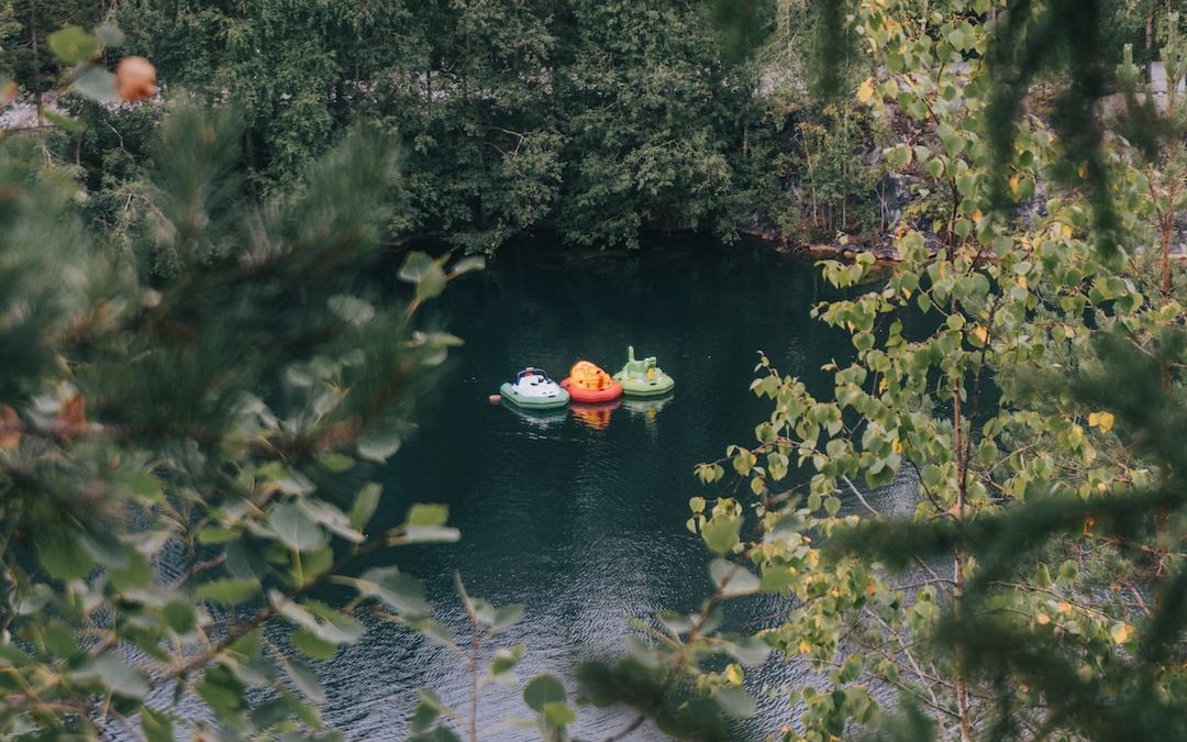 a couple of boats floating on top of a lake