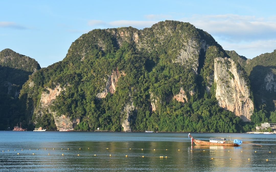 a boat floating on top of a lake surrounded by mountains