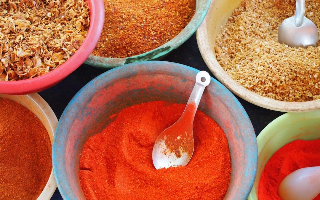 bowls of various spices and spoons on a table