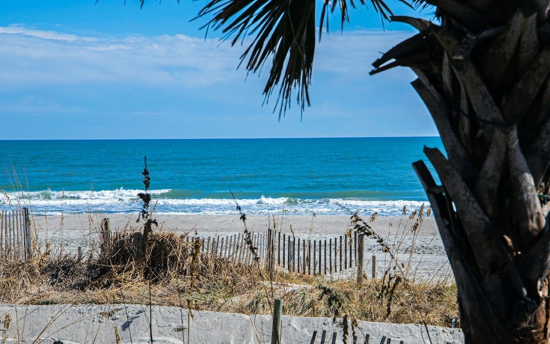 a view of a beach from behind a fence