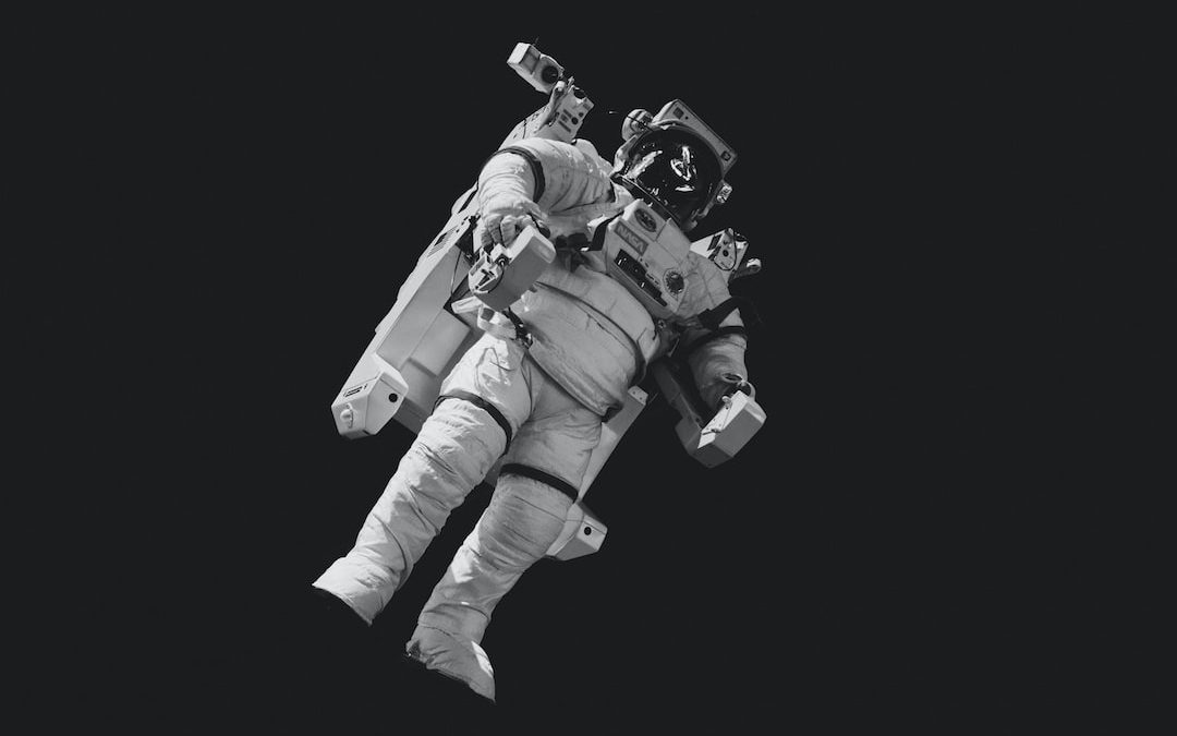 astronaut in white suit in grayscale photography