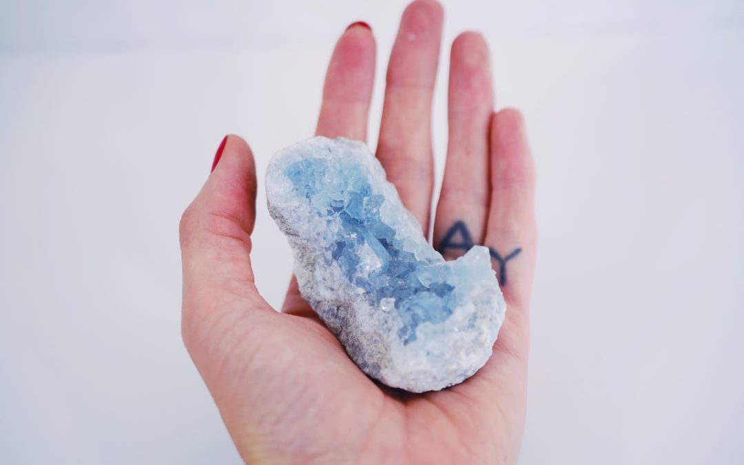 a person's hand holding a small piece of ice