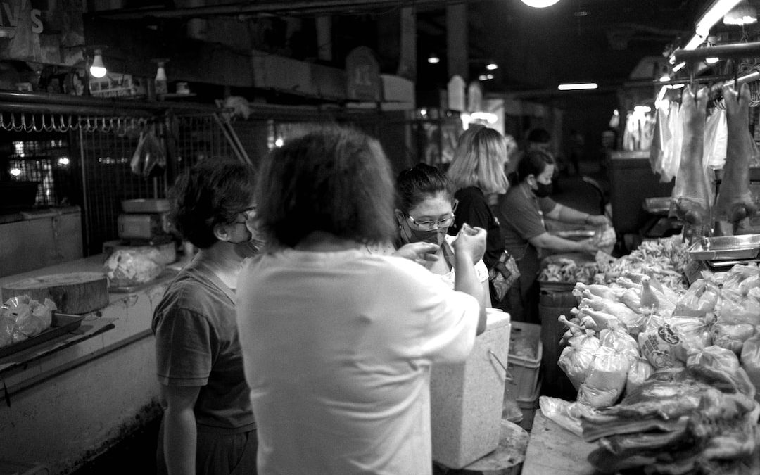a black and white photo of people shopping in a market