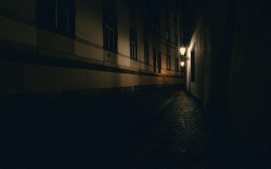 a dark alley at night with a street light on
