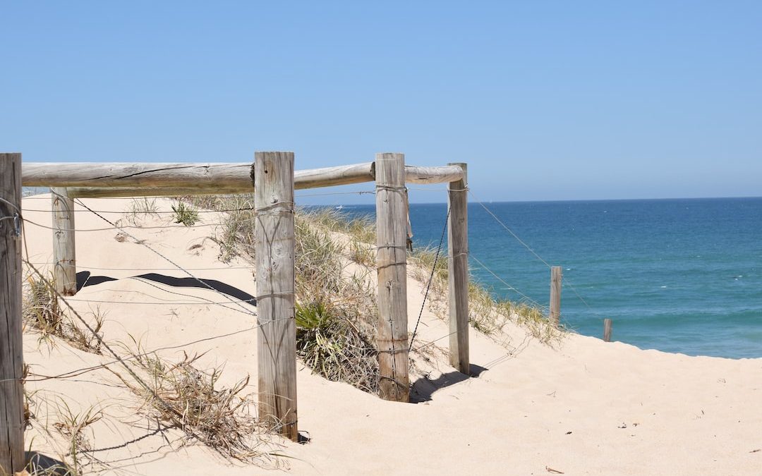 a wooden gate on a sandy beach near the ocean