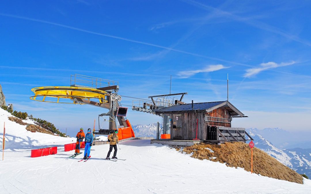 a couple of people standing on top of a snow covered slope