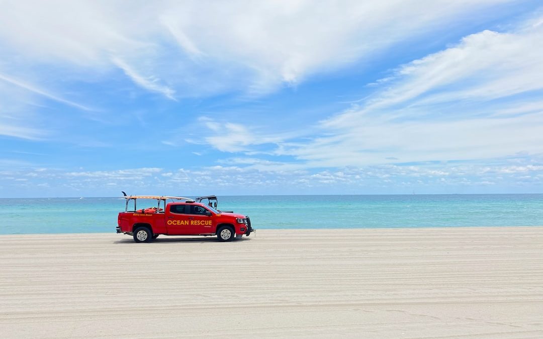 red suv on beach during daytime