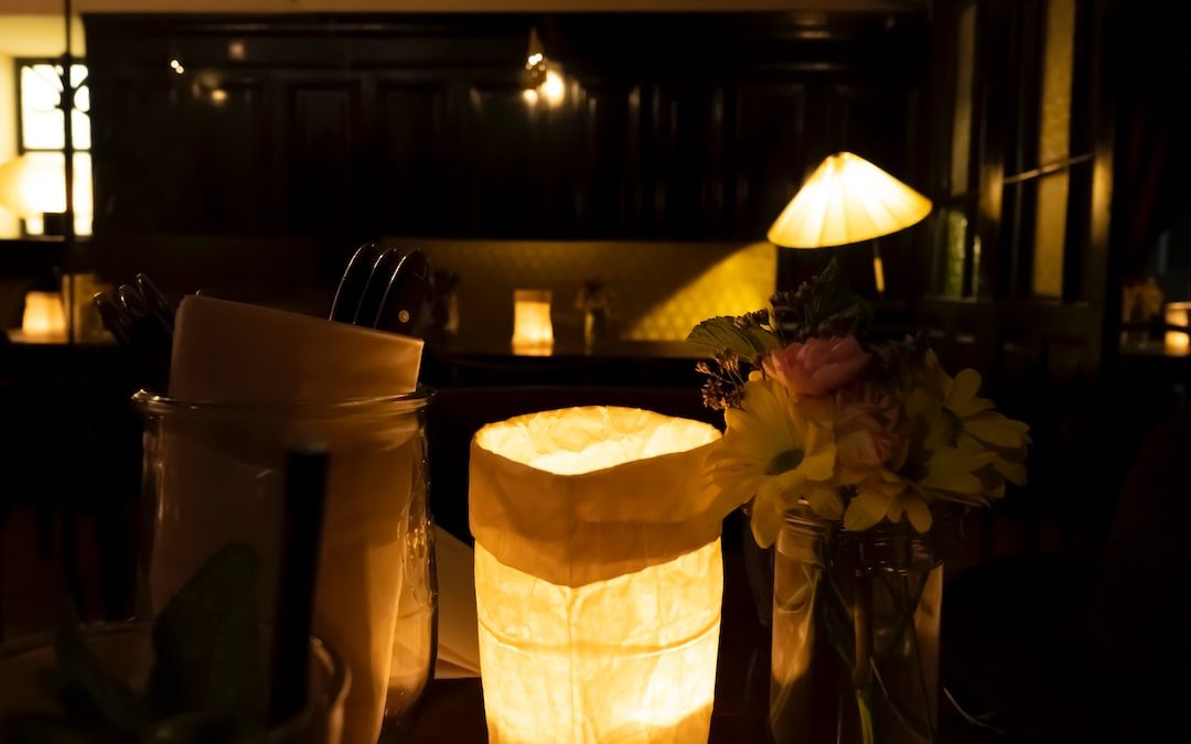 a table with a vase of flowers and a lit candle