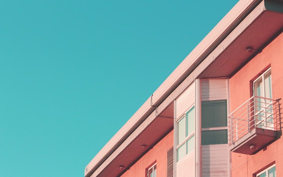 a pink building with a balcony and balconies