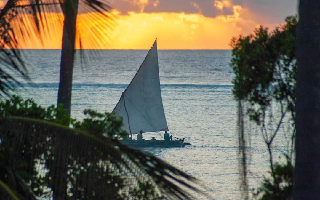 white sailboat on sea during sunset