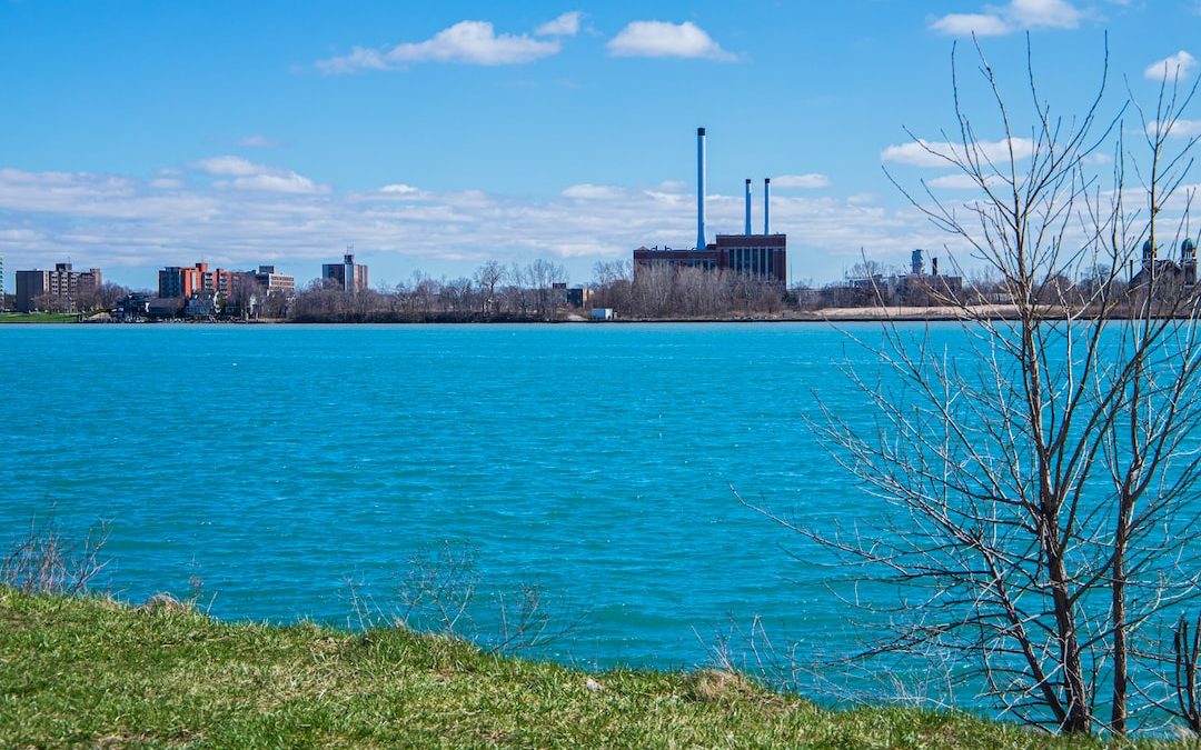 a large body of water with a factory in the background