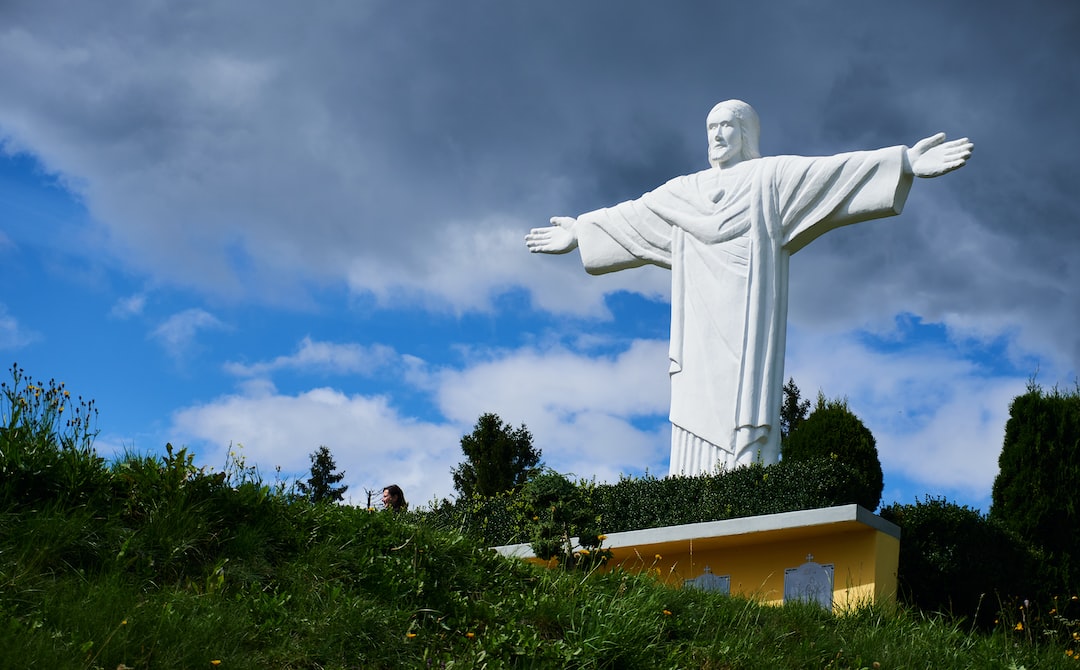 a large statue of jesus on top of a hill